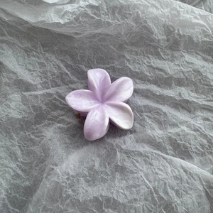 Detail of a purple flower hair claw clip with marble texture and acetate finish