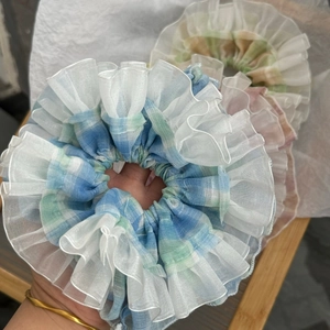 Detailed close-up showing plaid ruffled scrunchies in blue and pink organza fabric