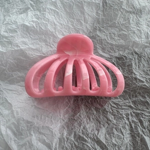Close-up of pink marble pattern hair claw clip with glossy finish and fan-shaped design