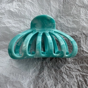 Detail of teal and white marble pattern large hair claw clip with multi-tooth design