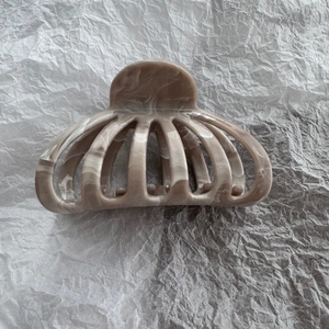 Macro detail of fan-shaped marble texture hair claw clip with mocha brown acetate finish