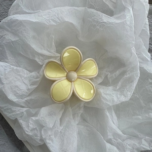 Detailed macro view of a yellow flower hair claw clip with creamy white borders