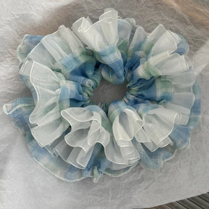 Detail of blue and green plaid scrunchie with layered white organza ruffles
