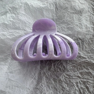Close-up of light purple marble pattern claw clip with smooth lacquer finish