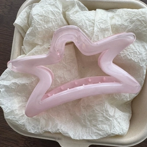 Dettaglio del fermaglio per capelli a forma di stella in resina rosa traslucida chiara