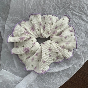 Detail of white scrunchie with purple rose print and decorative ruffled edges