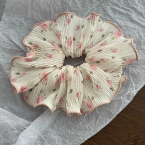 Macro shot of large scrunchie featuring pink floral rose prints and ruffled edges