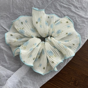 Detailed close-up of blue floral scrunchie with pleated chiffon and light blue edging