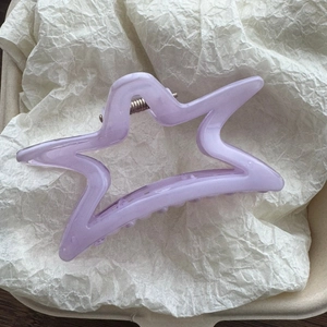 Dettaglio di un fermaglio per capelli a stella lavanda con texture marmorizzata lucida