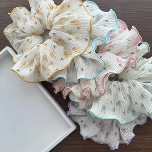 Floral pleated scrunchie set in five colors on a walnut wooden table and white tray