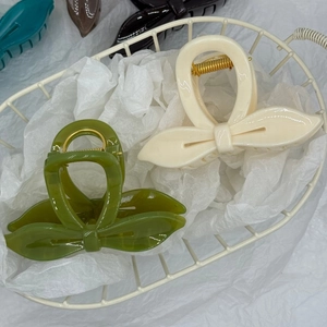 Détail de pinces à cheveux élégantes en forme de nœud en blanc crème et vert