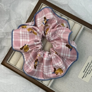 Dettaglio dello scrunchie a quadretti rosa con bassotto e bordi blu ricamati