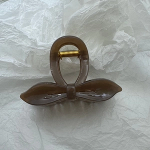 Détail d'une pince à cheveux ambre en forme de nœud avec ressort doré brillant