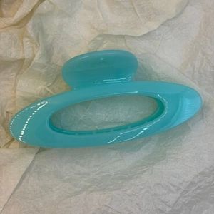 Vue détaillée de la pince à cheveux ovale creuse bleu brillant avec ressort et dents