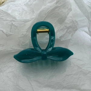 Détail d'une pince à cheveux nœud bleu canard montrant le ressort en métal doré