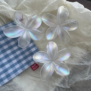 Three pieces of iridescent plumeria flower hair claws with a pearlescent finish