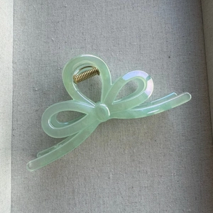 Detail of mint green iridescent bow hair claw clip with pearlescent translucent finish