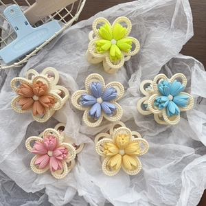 Close-up of six matte tulip flower hair claws in assorted macaron colors on a white backdrop