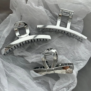 Three-piece set of silver metallic claw clips in rectangle, arc, and bow designs