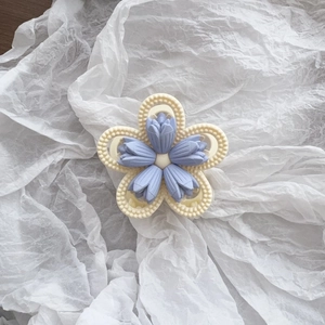 Detail shot of matte lavender tulip flowers on a cream floral hair claw clip