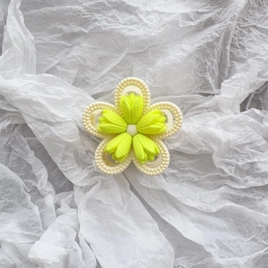 Detail of matte cream tulip hair claw clip with yellow flower and beaded texture