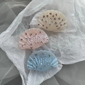 Pinces à cheveux en forme de coquillage en blanc crème, rose et bleu avec motifs étoilés