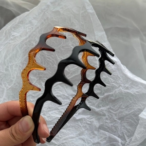 Thick wavy non-slip hairbands in black and amber colors with fine teeth for high volume hair