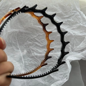 Wave-shaped tooth headbands in black and amber colors for hair styling and volume
