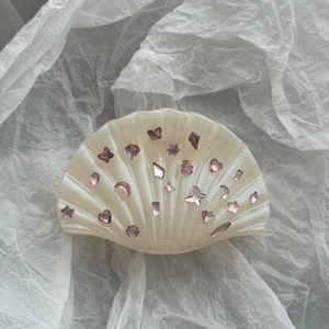 Détail de la pince à cheveux coquillage blanc nacré avec strass roses papillon et étoile