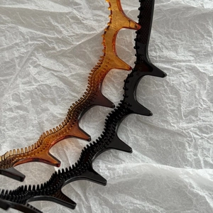 Two wavy headbands in amber and black with non-slip teeth for high-volume hairstyles