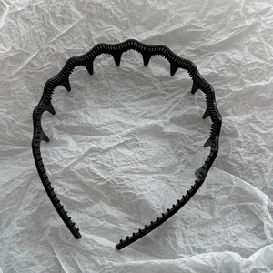Close-up of black wavy headband with fine teeth for a high skull top hairstyle effect