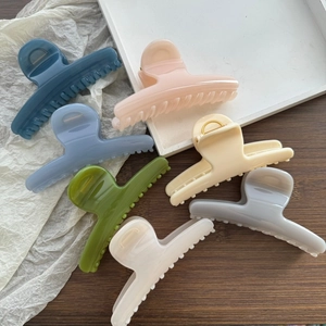 Selection of large colorful spring hair claws in matte colors on a wooden surface