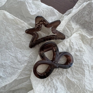 Close-up of star and bow shaped hair claws in translucent dark coffee brown resin finish