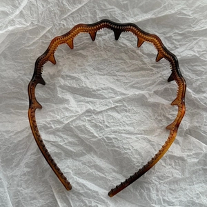 Close-up of amber wavy headband with fine inner teeth for voluminous high cranial top hair