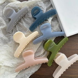 Detailed view of large spring-loaded butterfly hair clips in various Morandi colors