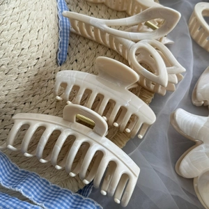 Detaillierte Sammlung von cremefarbenen Haarklammern mit Marmorharzstruktur und Blumenformen