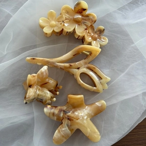Set of four yellow marble amber hair claws including flower and starfish shapes
