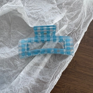 Detail of blue gingham rectangular hair claw clip with translucent crystal texture