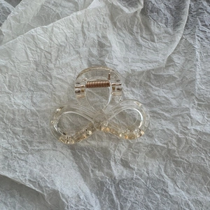 Detail of transparent star hair claw clip with golden metal spring on white background