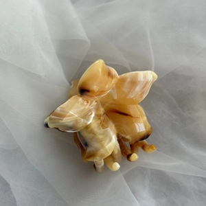 Detailed view of amber tortoise shell flower hair claw clip on soft white mesh fabric