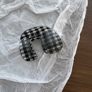 Close-up of a minimalist black and white gingham checkered hair claw clip with glossy finish