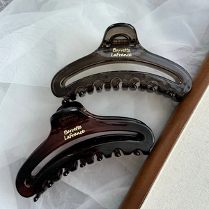 Detail of elegant French acrylic hair claws in translucent grey and amber tortoise shell