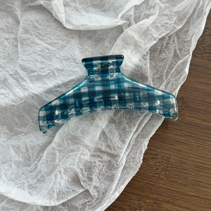 Detail of blue and white gingham hair claw clip with a strong gold metal spring