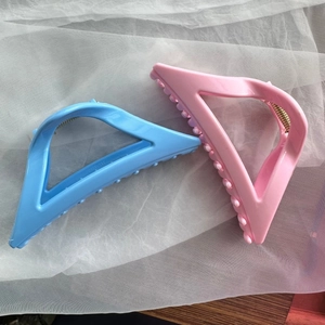 Detail of pink and blue soft silicone hair claw clips with gold metal springs on white tulle