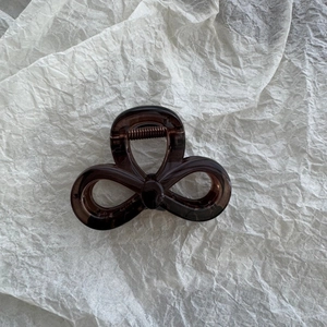 Detail view of dark coffee translucent star claw clip with durable metal spring