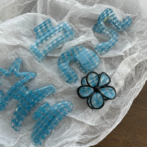 Set of light blue gingham pattern hair claws in various geometric shapes on white paper