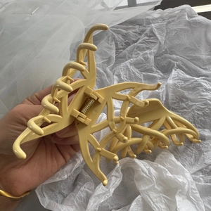 Pince à cheveux papillon évidée jaune clair avec motif de maille élégant et moderne
