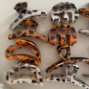 Detailed top view of leopard and tortoiseshell pattern hair claws in various shapes