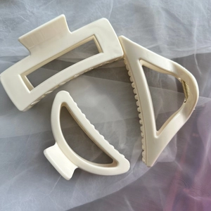 Detail of cream matte silicone shark hair claw clips in geometric rectangle and triangle shapes