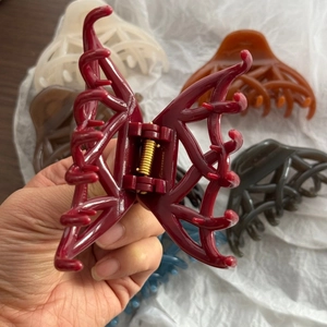 Détail d'une pince à cheveux rouge foncé à effet gelée avec structure ajourée